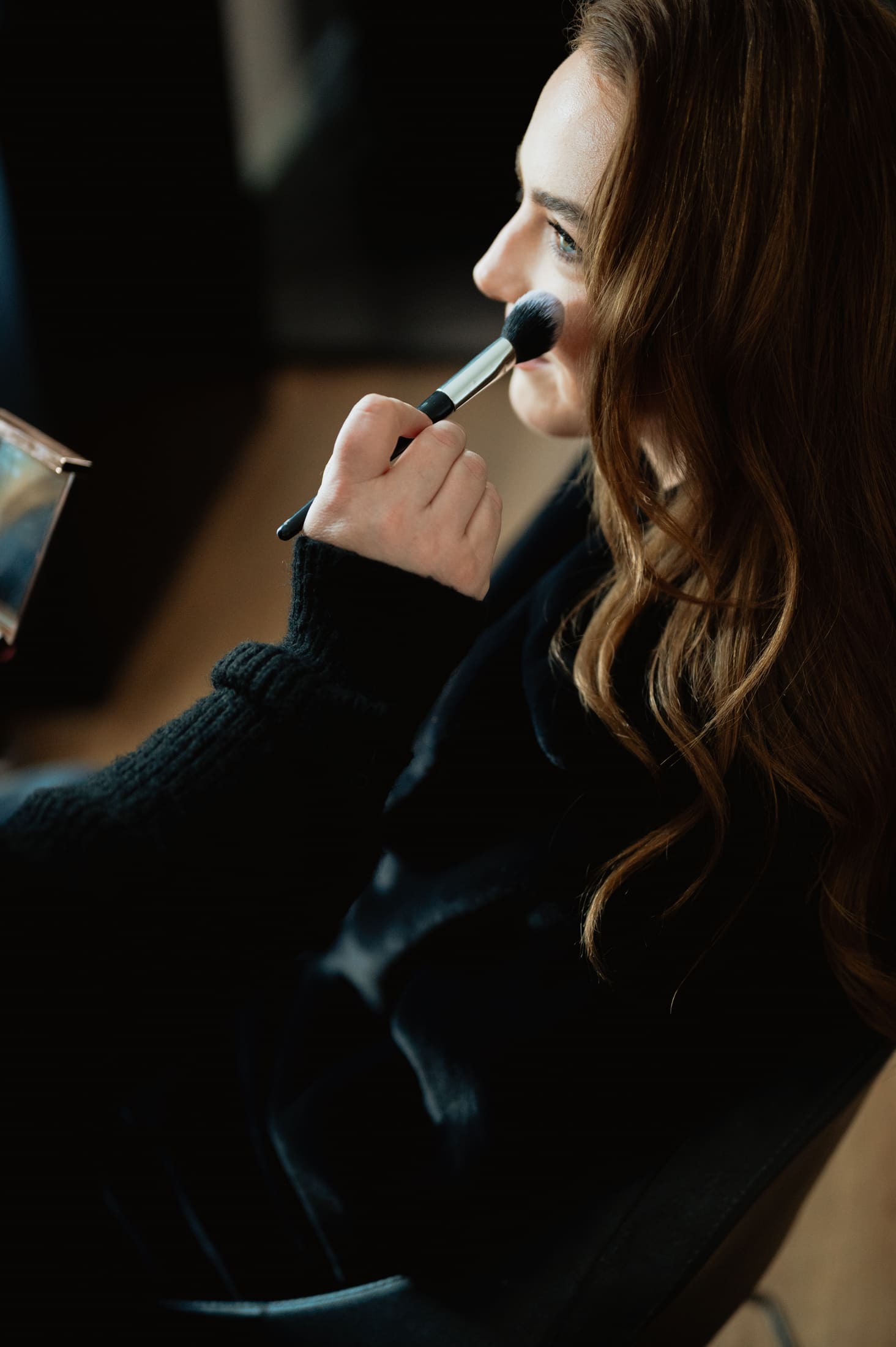 Makeup artist applying blush on a wedding morning